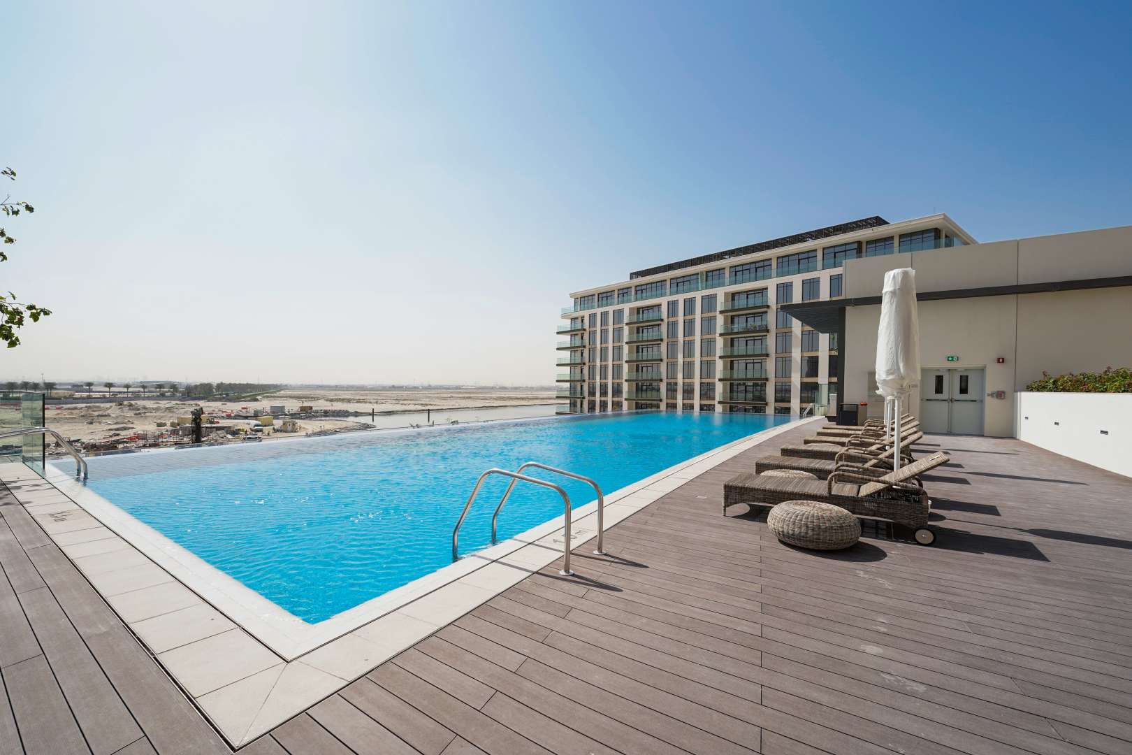 Rooftop pool with sun loungers at The Cove 3, Dubai Creek Harbour apartment complex