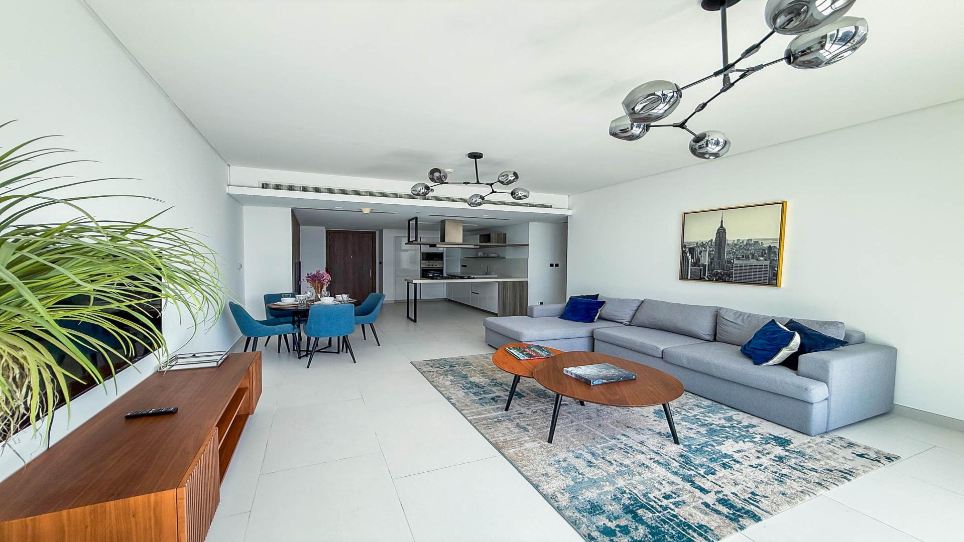 Modern living room in Palm Jumeirah apartment with sleek furniture and open kitchen layout