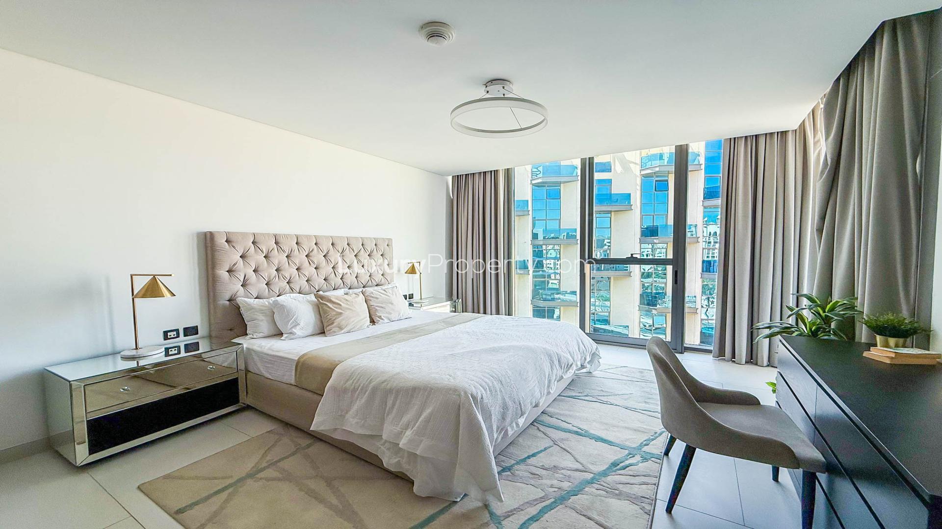 Modern furnished living room in Palm Jumeirah apartment, featuring sleek decor and open kitchen