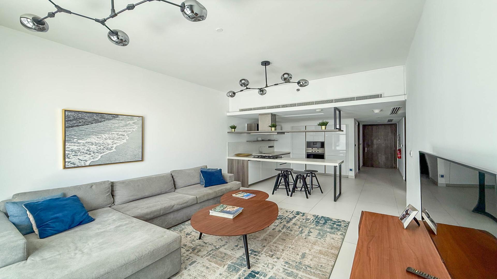 Modern furnished living room in Soho Palm Jumeirah apartment for rent with open kitchen