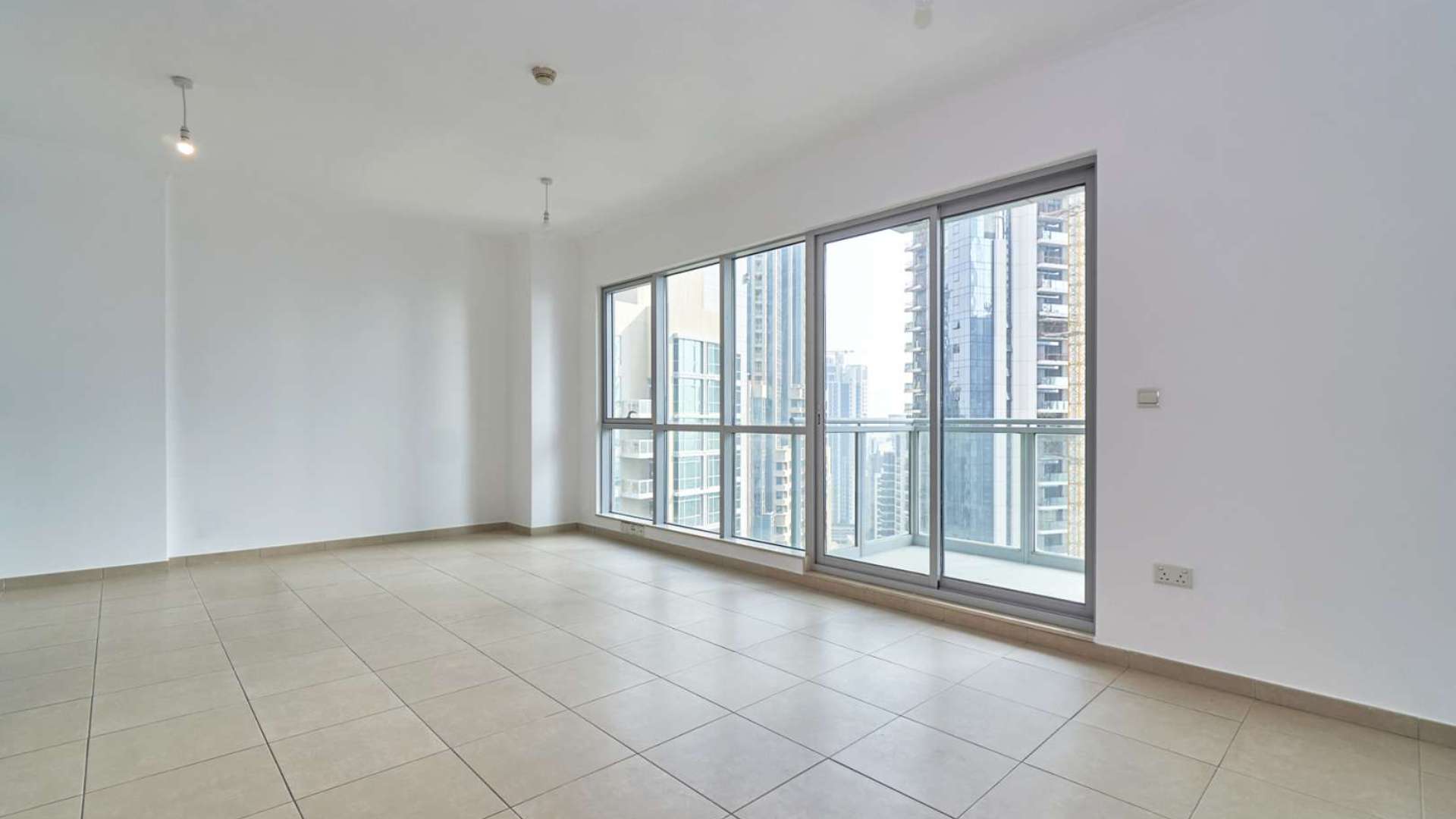 Empty living area with tiled floor and wooden accents in Downtown Dubai apartment