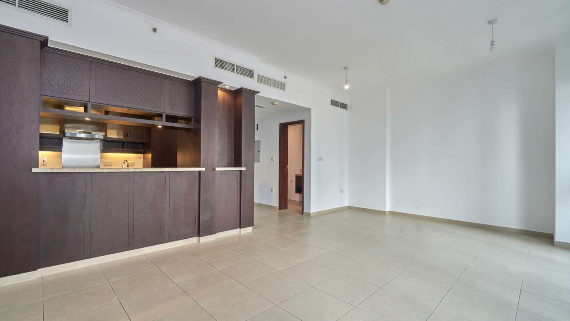 Empty living room with large windows in Downtown Dubai apartment, offering city views