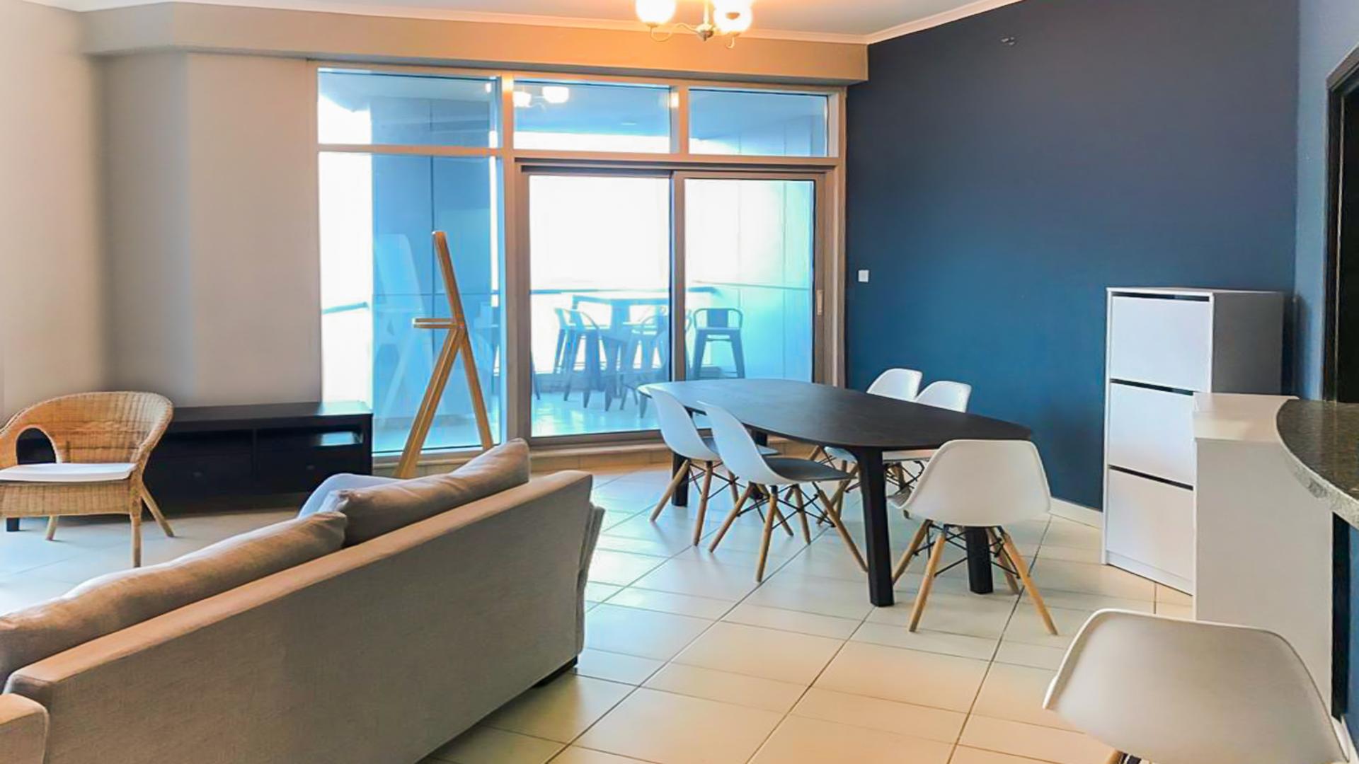 Modern living room in furnished Dubai Marina apartment with city view windows