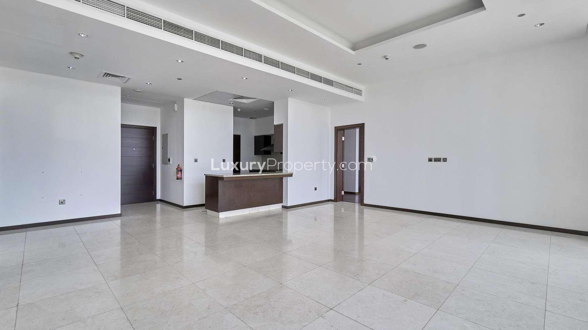 Empty living room in Tiara Residences apartment, Palm Jumeirah, with modern finishes and tiled floor