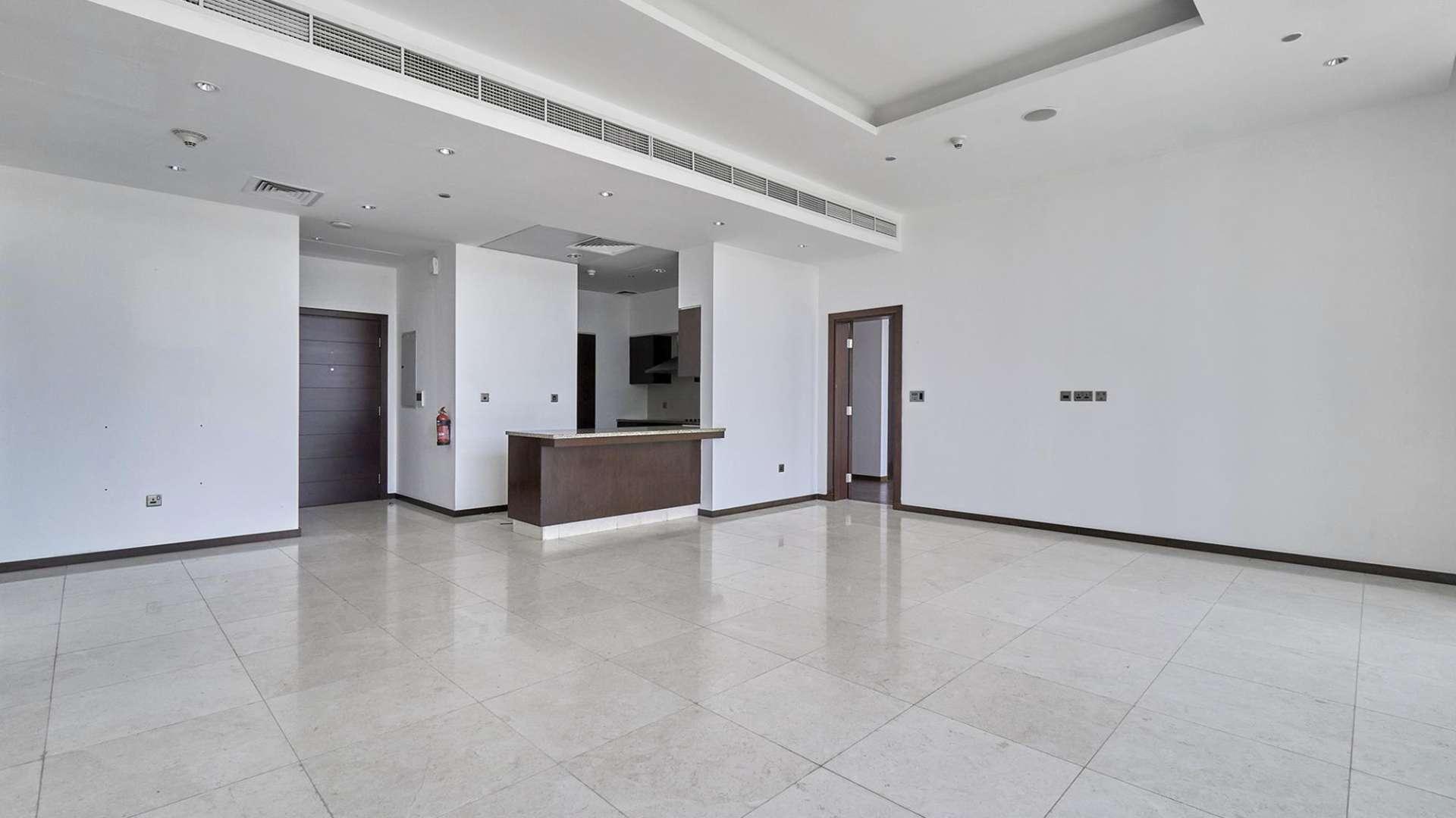 Empty living room in Tiara Residences apartment, Palm Jumeirah, with modern finishes and tiled floor