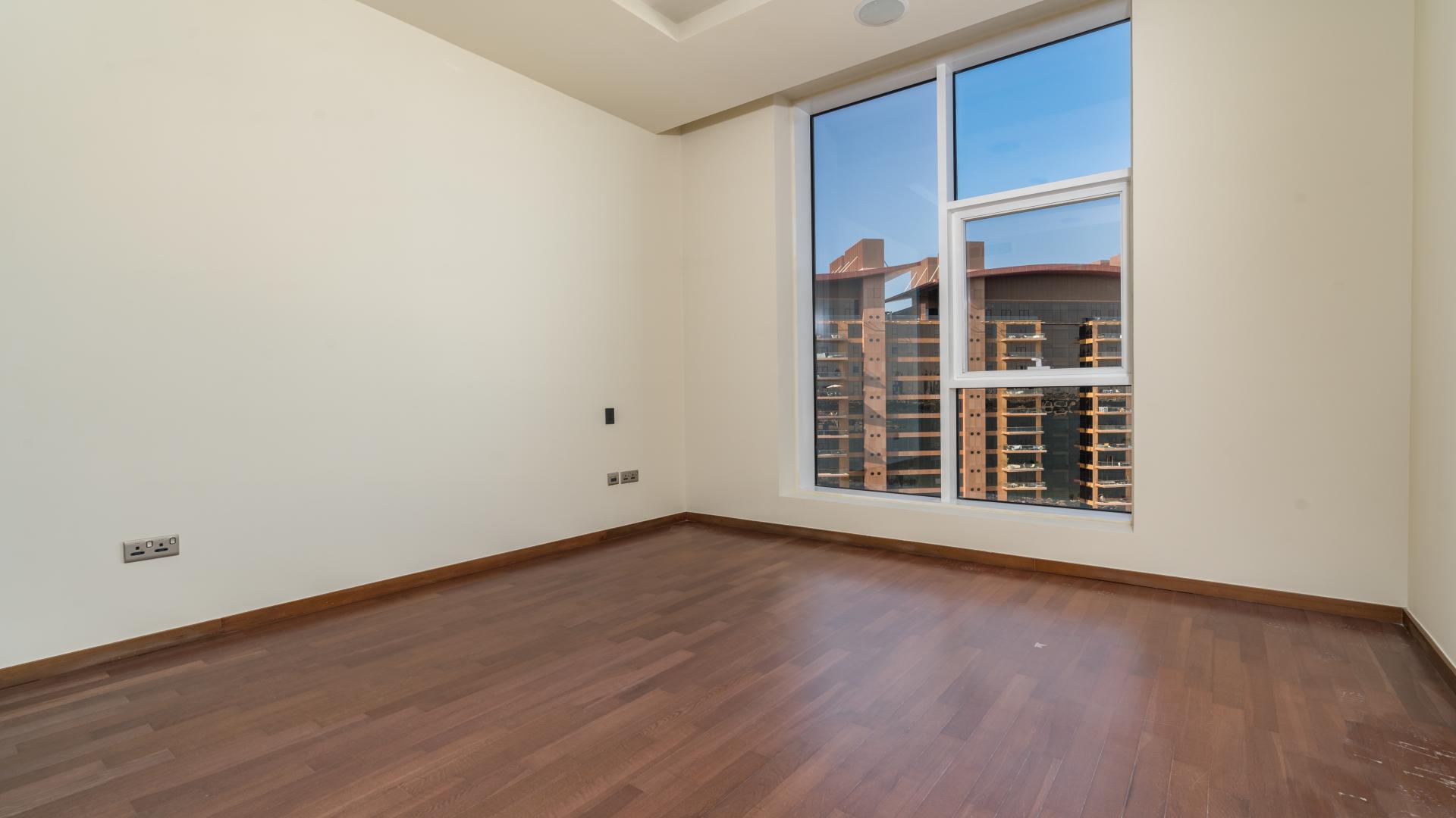 Empty bedroom with wooden floor and large window in Tiara Residences, Palm Jumeirah apartment