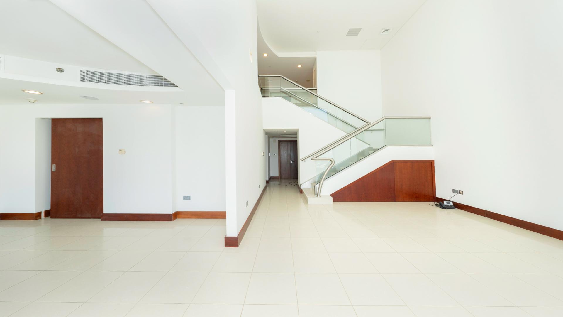 Contemporary duplex apartment interior in Jumeirah Living WTC, featuring expansive windows and skyline views