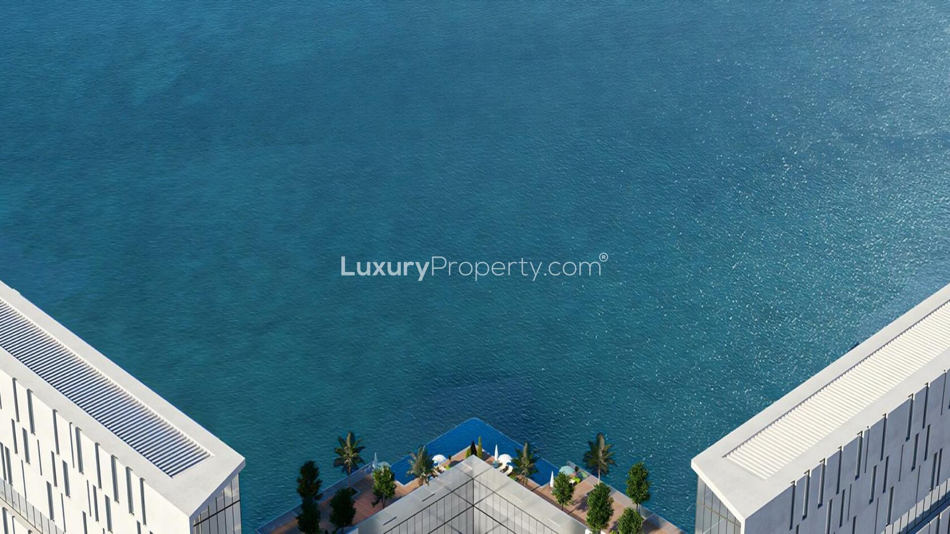Beachfront view with blue umbrellas at Al Marjan Island, Moonstone community, apartment LP38903
