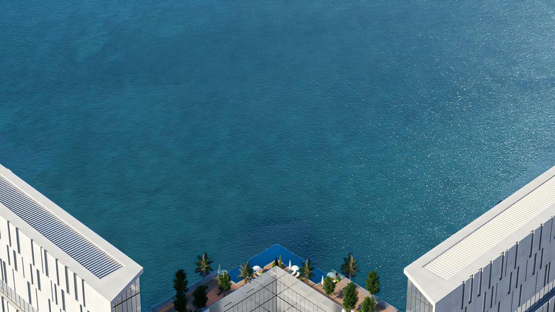 Beachfront view with blue umbrellas at Al Marjan Island, Moonstone community, apartment LP38903