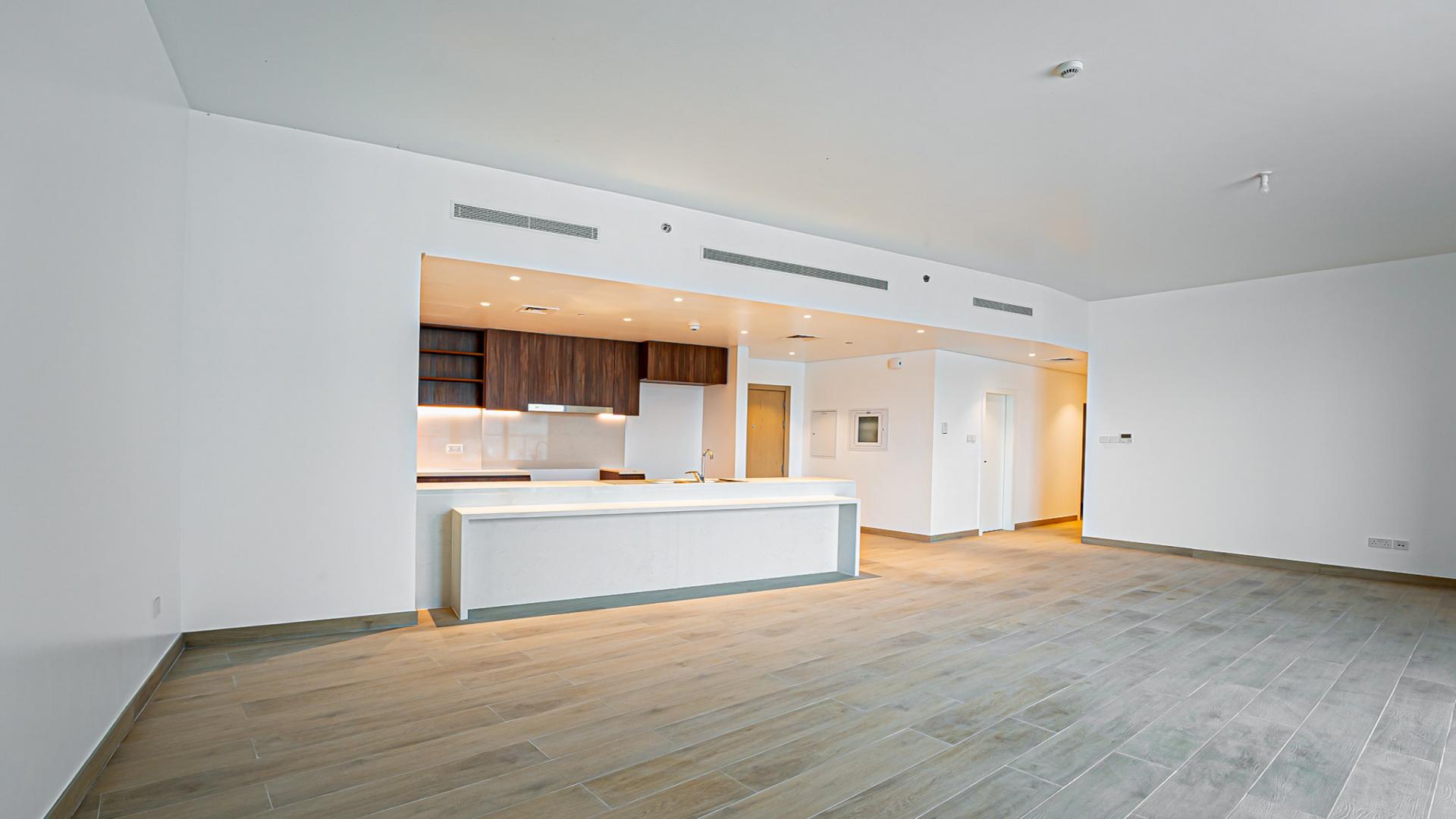 Modern open-plan kitchen and living area in Jumeirah La Mer waterfront apartment for sale