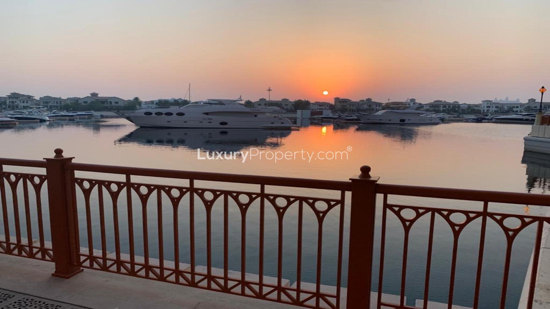 "Sunset marina view from Palm Jumeirah apartment balcony, yachts in serene waterscape.",Empty bedroom with wooden closets in Palm Jumeirah apartment, Marina Residences 1