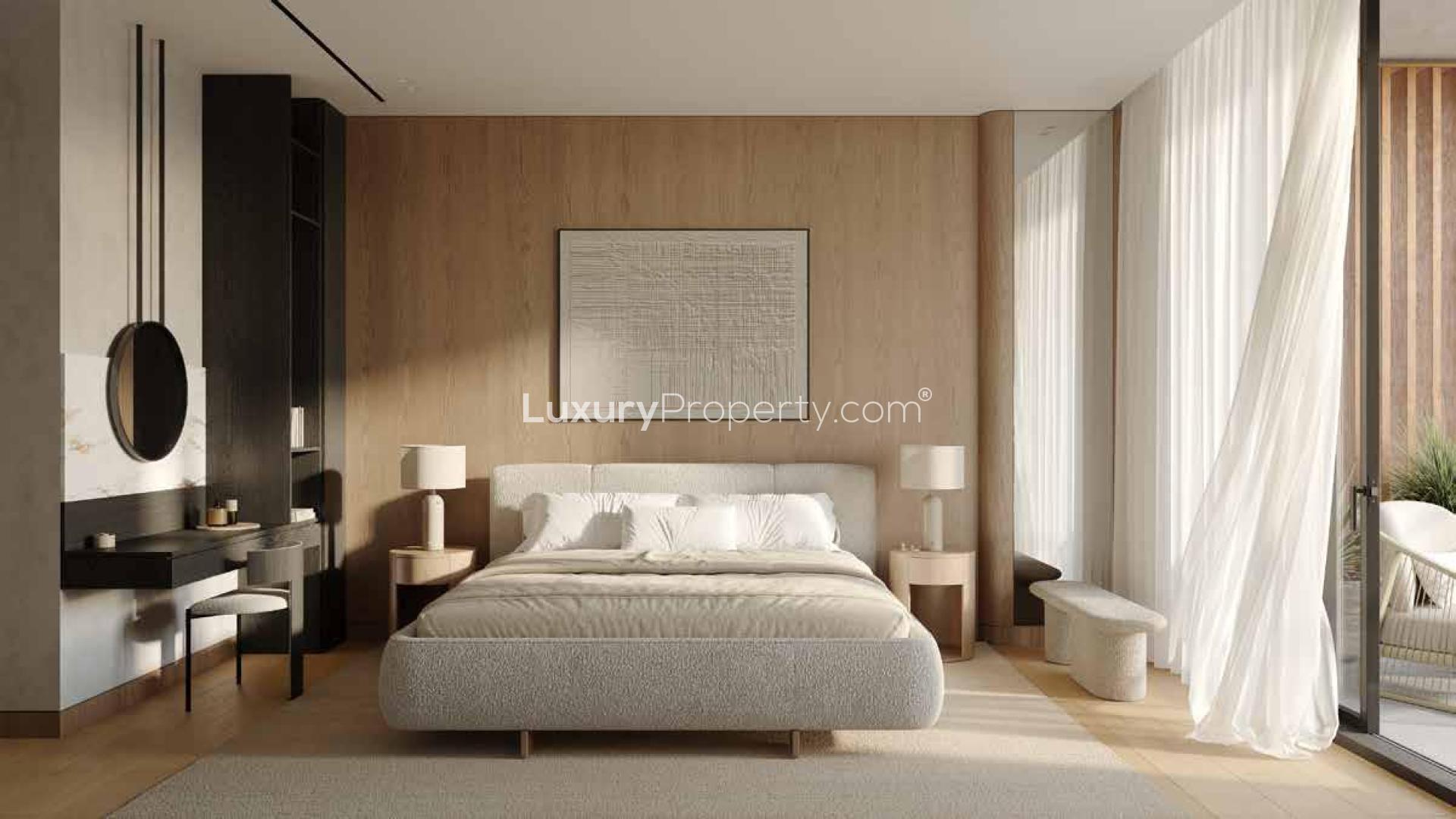 Modern kitchen in Al Barari apartment for sale, featuring sleek wood cabinetry and island