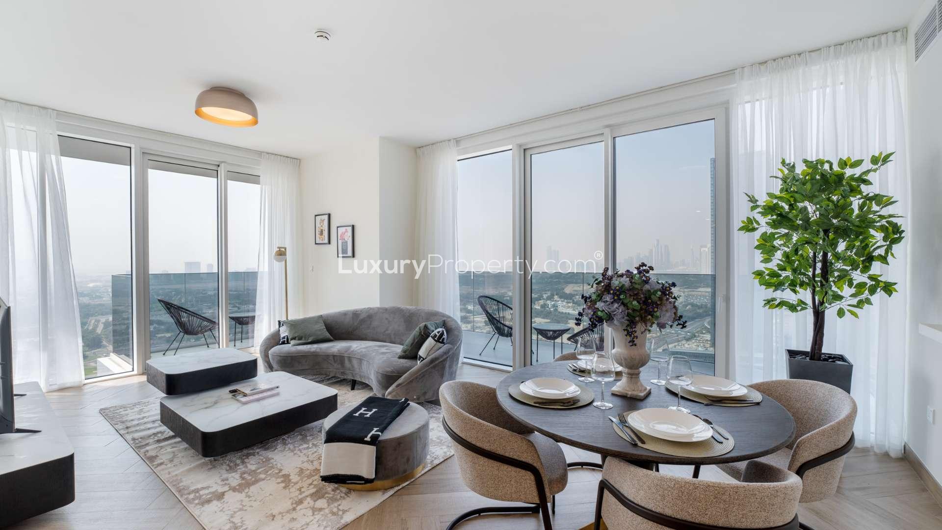Modern living room and dining area in Al Kifaf apartment, featuring large windows