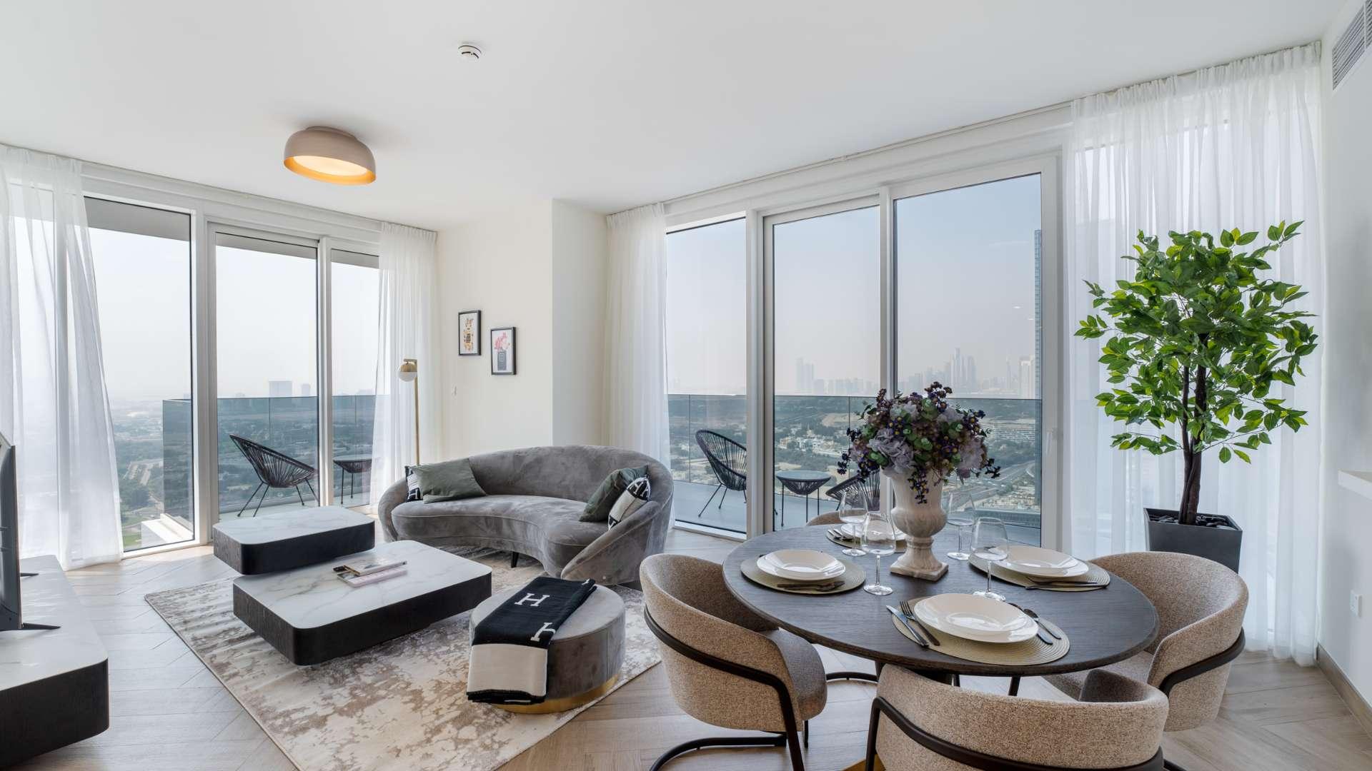 Modern living room and dining area in Al Kifaf apartment, featuring large windows