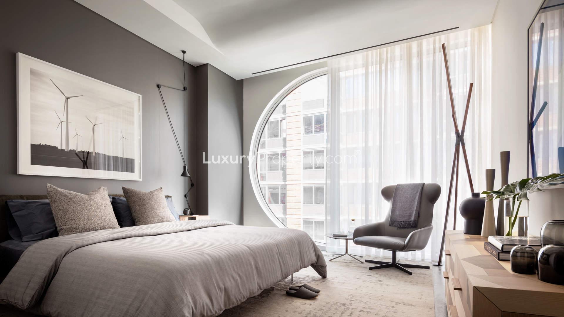 Stylish bedroom with unique circular window in West Chelsea apartment, Manhattan