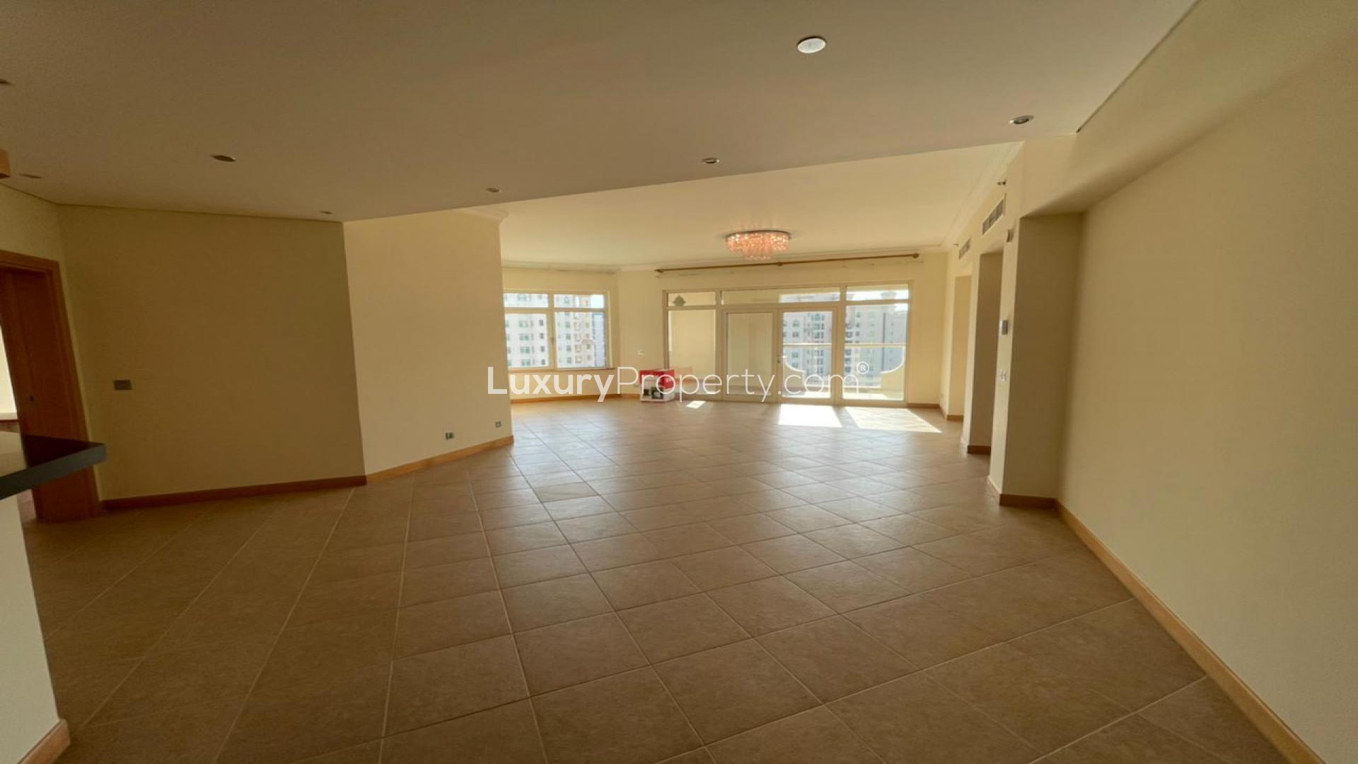 Empty room in Shoreline Apartments, Palm Jumeirah, with tiled floor and open door