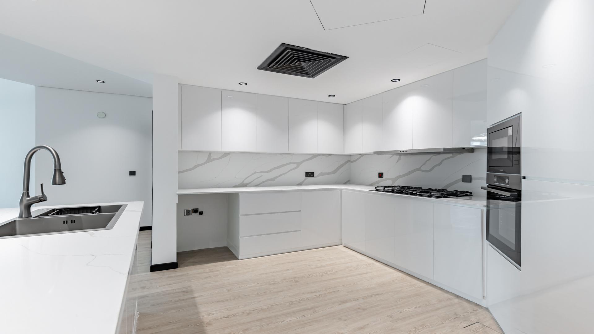 Fully upgraded modern kitchen in Shoreline Apartment, Palm Jumeirah with sleek white cabinetry