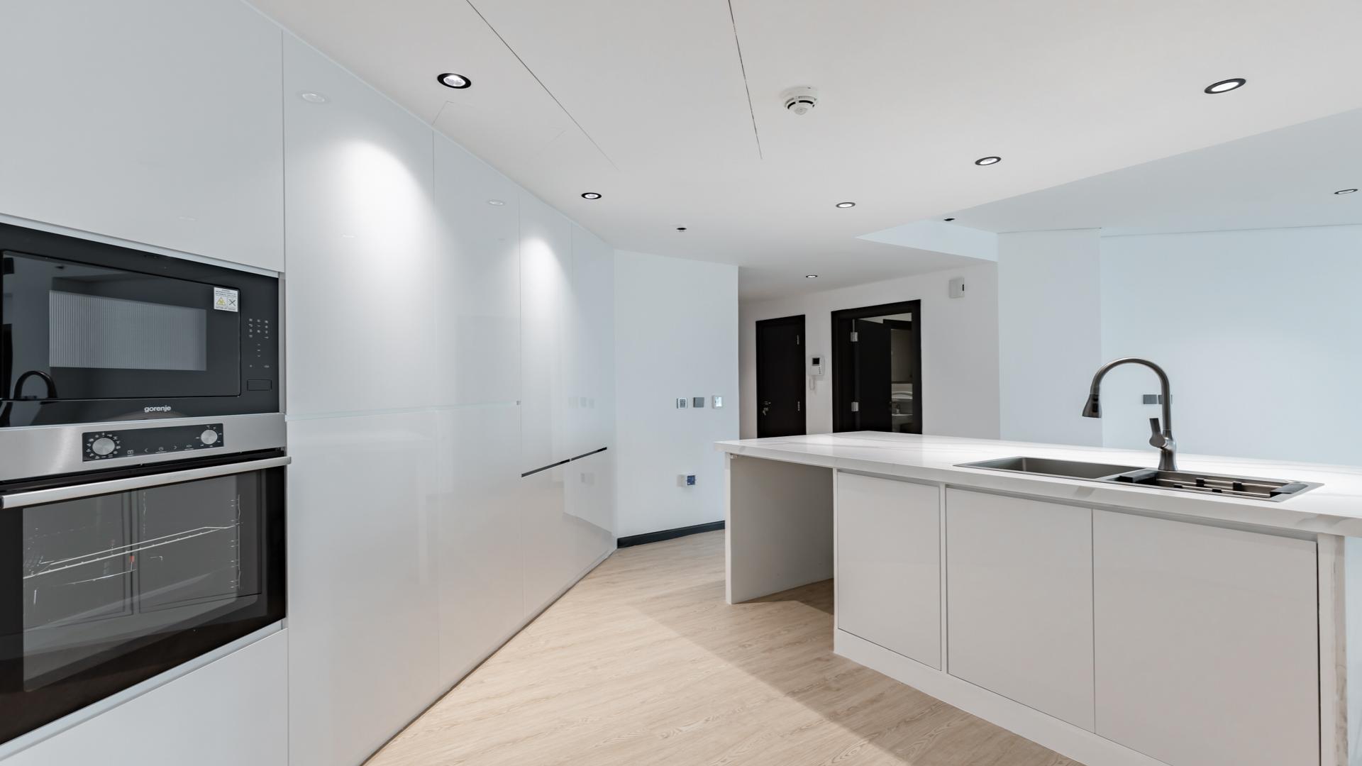 Modern kitchen in fully upgraded Shoreline apartment, Palm Jumeirah, with sleek white cabinetry