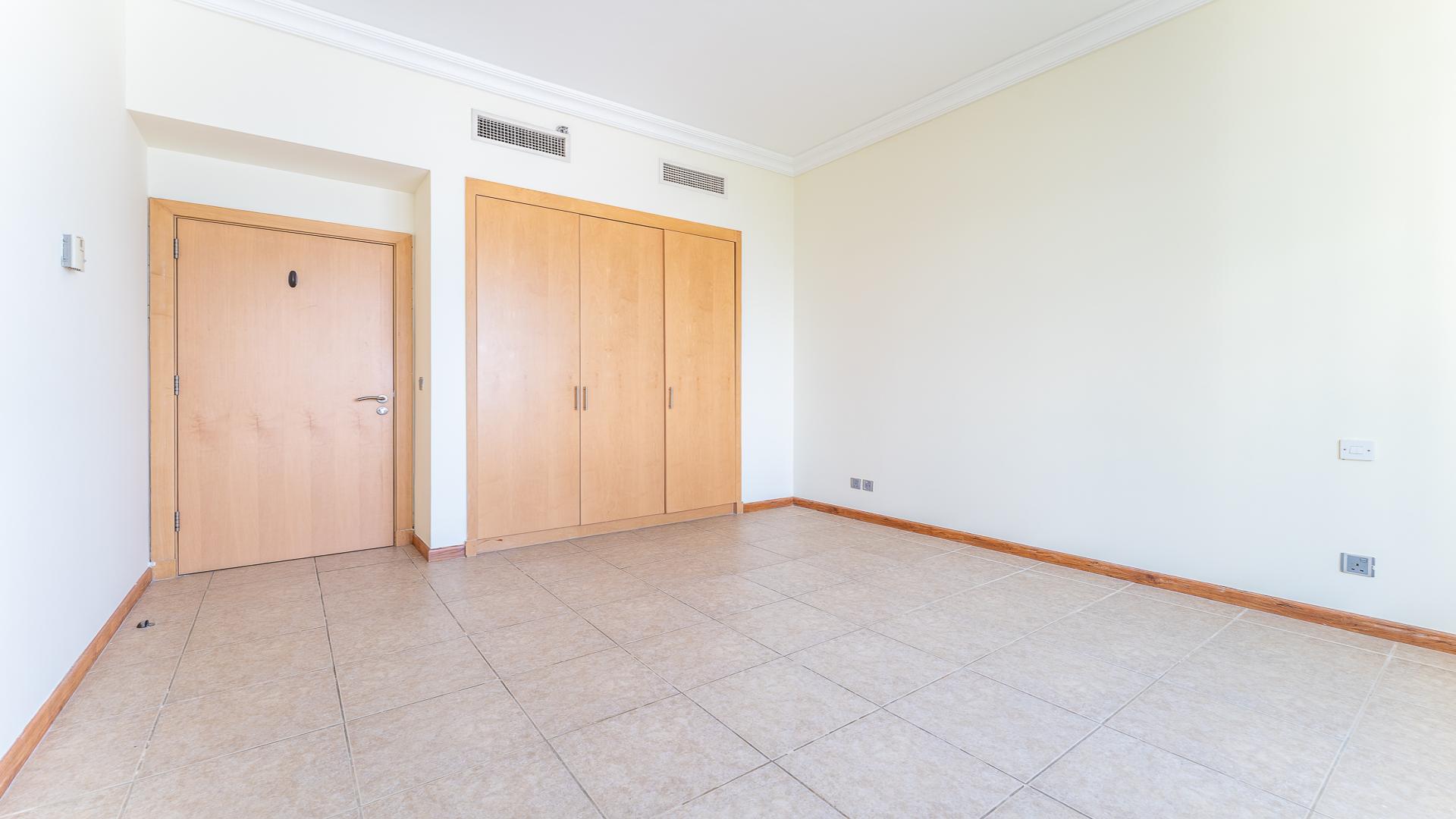Modern kitchen in Shoreline Apartments, Palm Jumeirah, with wood cabinets and granite countertops