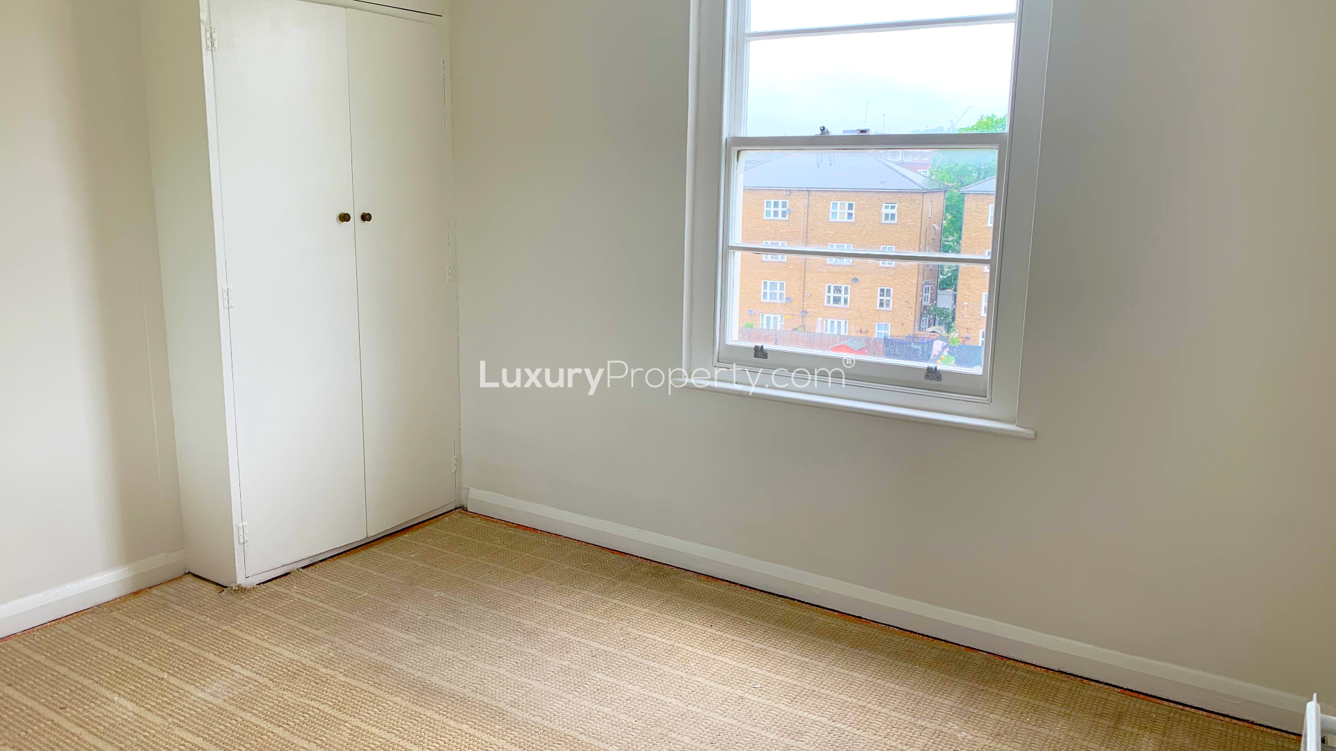 Bright room with large window in Hilltop Court apartment, Alexandra Road, London