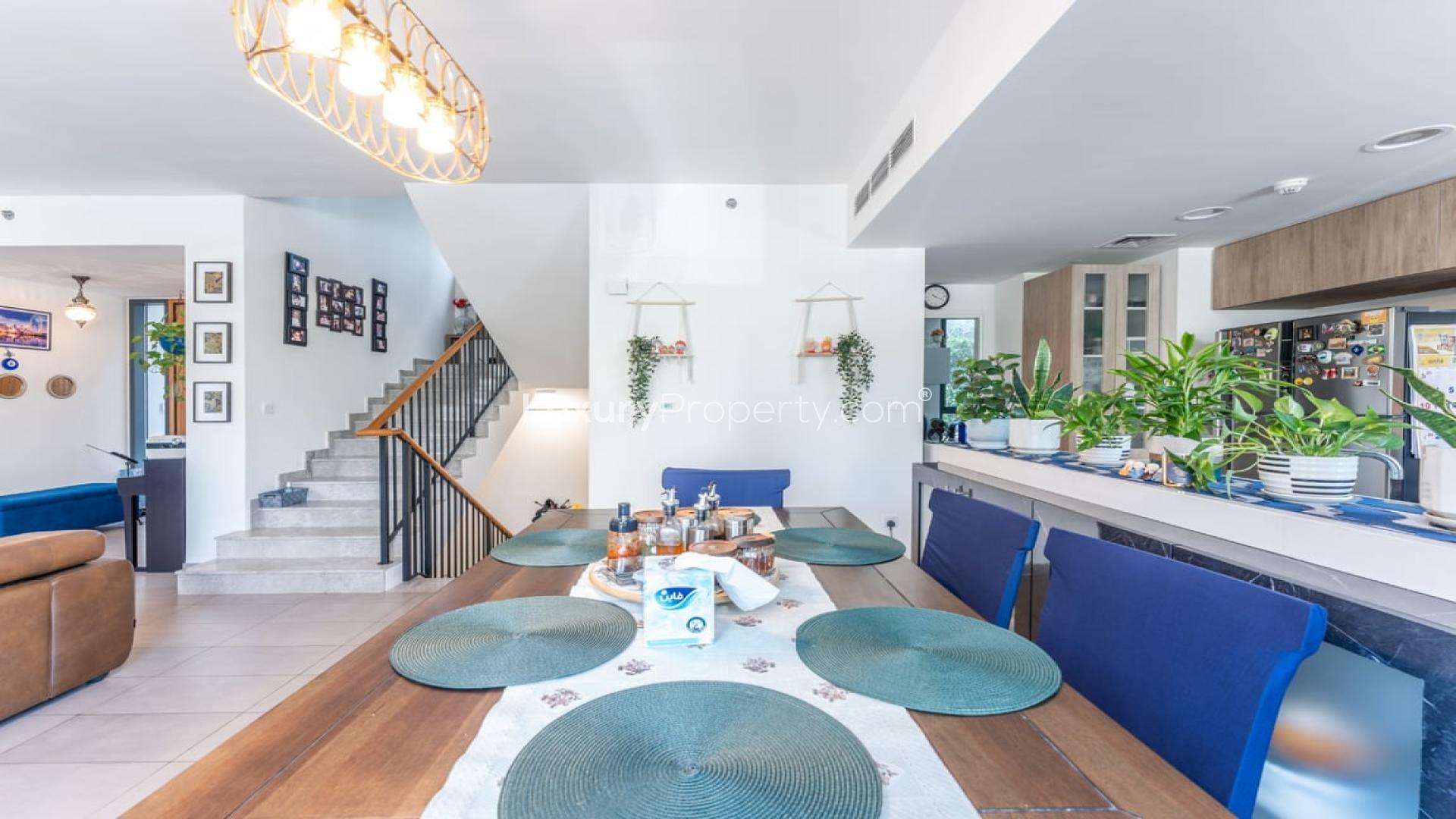 Contemporary living room in Dubai Hills Estate apartment with modern decor and staircase view