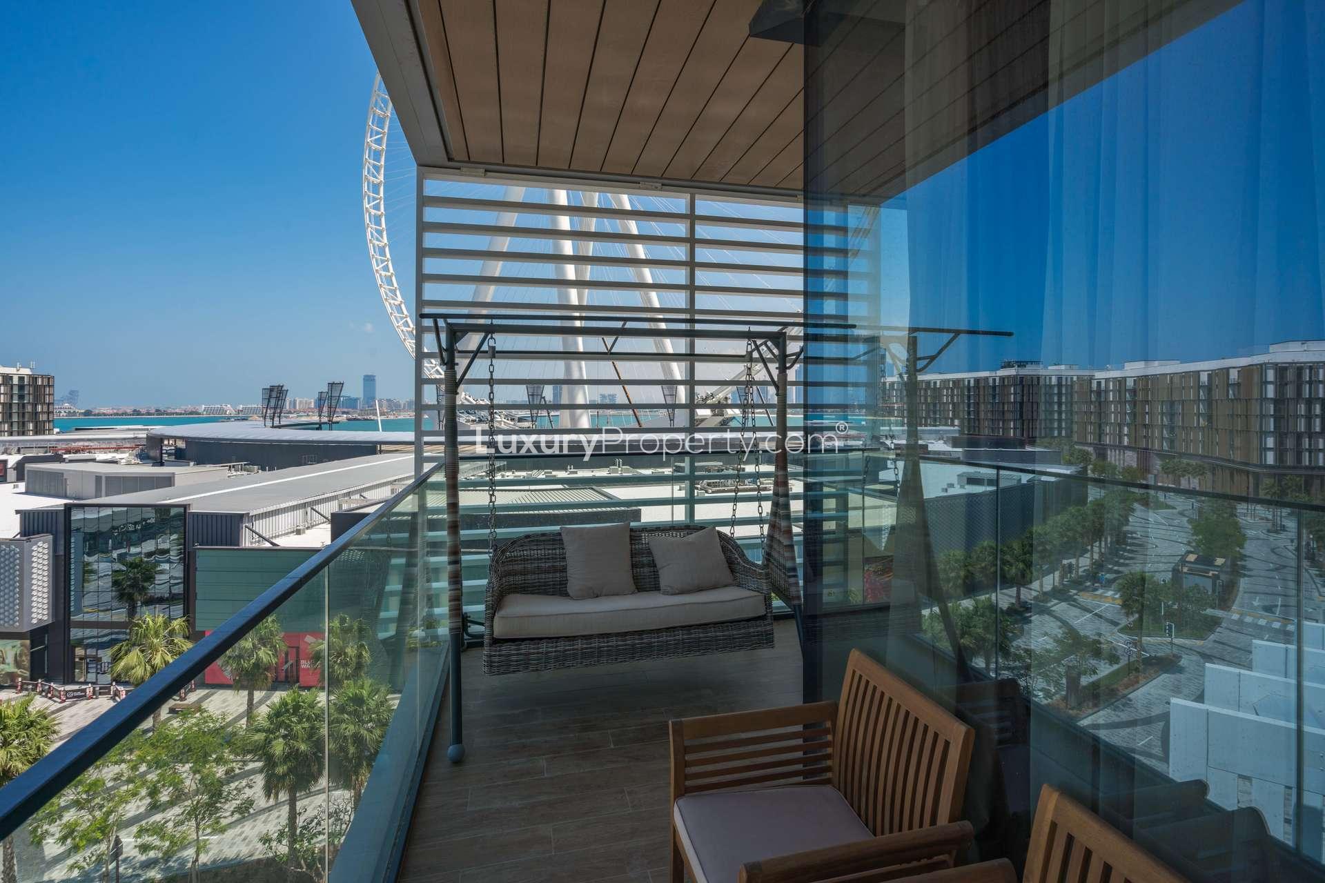 Modern living room in Bluewaters Island apartment with city view, marble dining table, vibrant chairs
