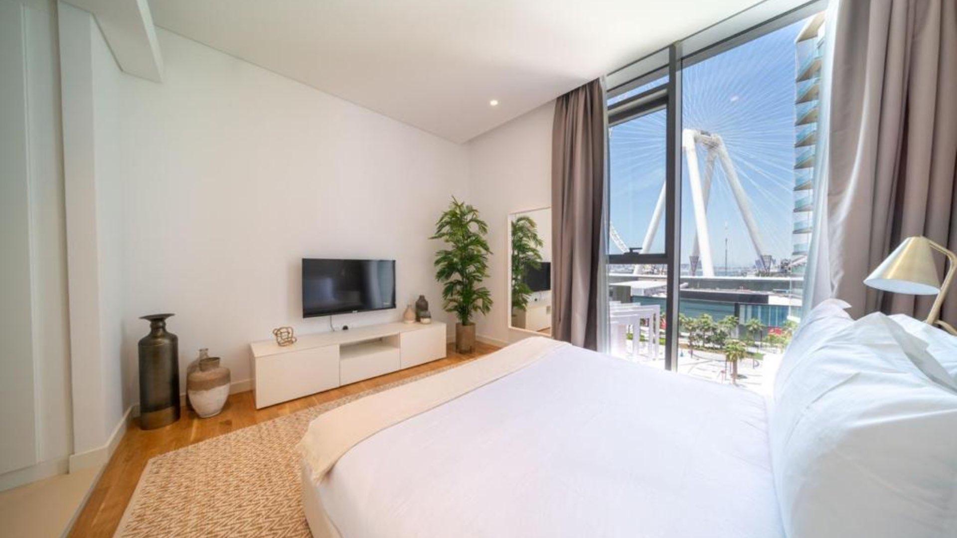 Balcony view of modern Bluewaters Residences apartment with outdoor seating and lush greenery