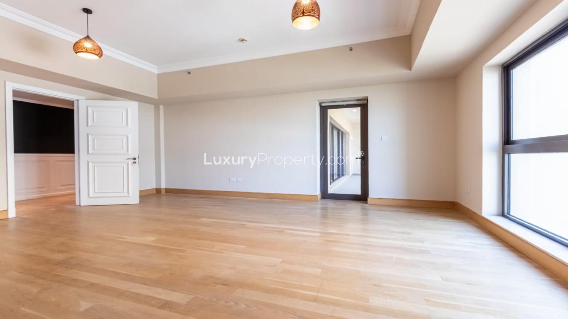 Empty living room in upgraded Golden Mile Residence, Palm Jumeirah with wooden flooring