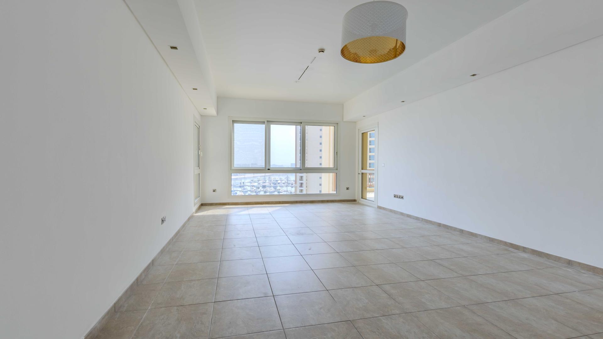 "Spacious empty room in Marina Residences 3-bedroom apartment, Palm Jumeirah for sale.",Bright living room in 3-bedroom apartment, Marina Residences, Palm Jumeirah for sale