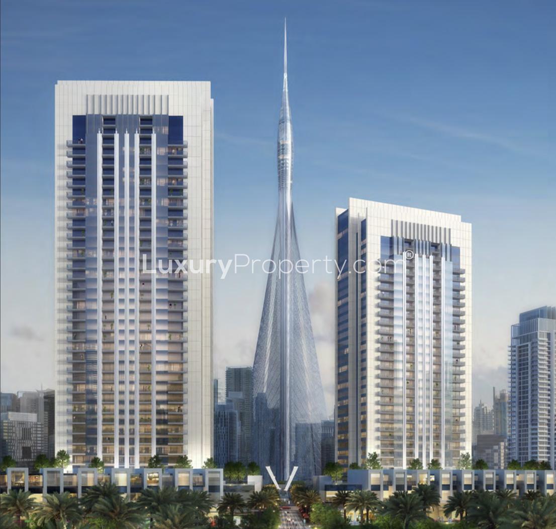 "View of Creek Gate, Dubai Creek Harbour with palm-lined walkway and modern skyscrapers.",Creek Gate apartment buildings in Dubai Creek Harbour with iconic tower view