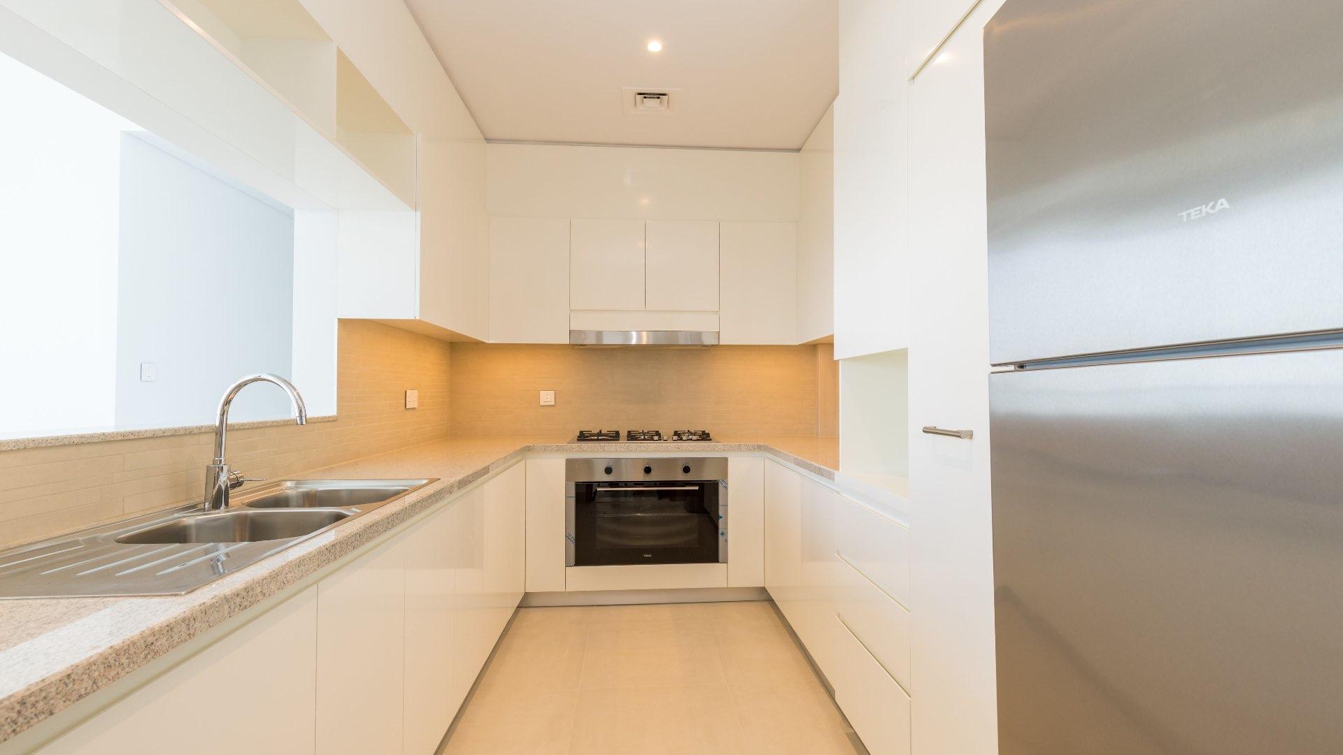 "Spacious Downtown Dubai apartment interior with large windows and modern finishes, high floor view.",Modern kitchen in spacious Downtown Dubai apartment with sleek appliances and ample counter space