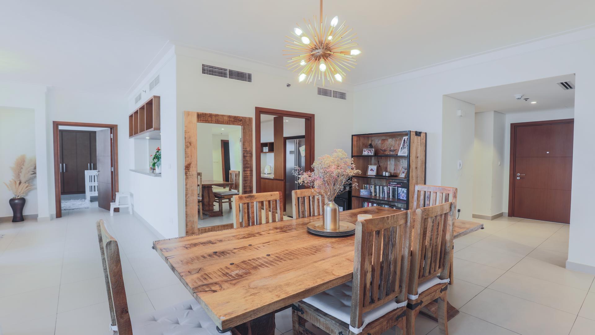 "Spacious dining area in 3-bedroom apartment, Dubai Creek Harbour, elegant decor and natural light.",Dining area in 3-bedroom apartment at Dubai Creek Harbour, modern decor and wooden furniture