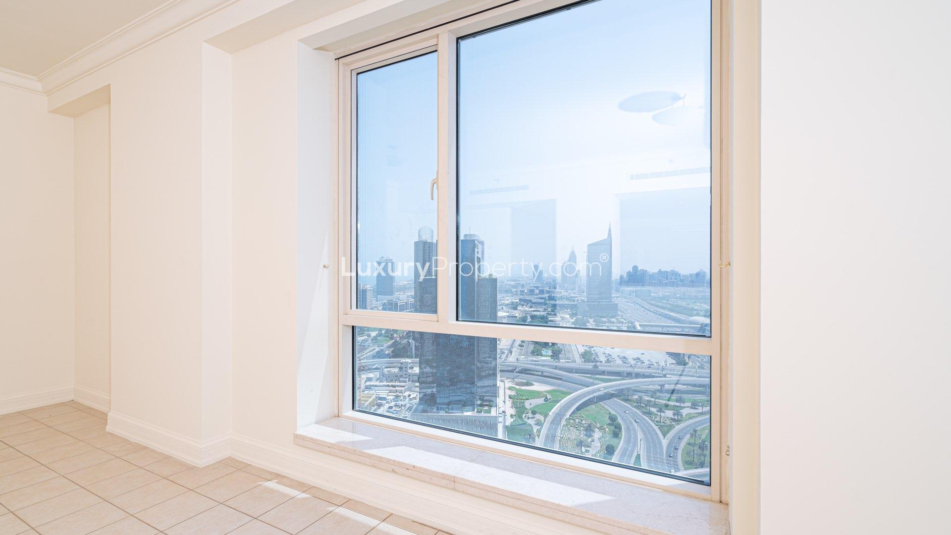 Spacious balcony with glass railing offering stunning Dubai Marina skyline and golf course views