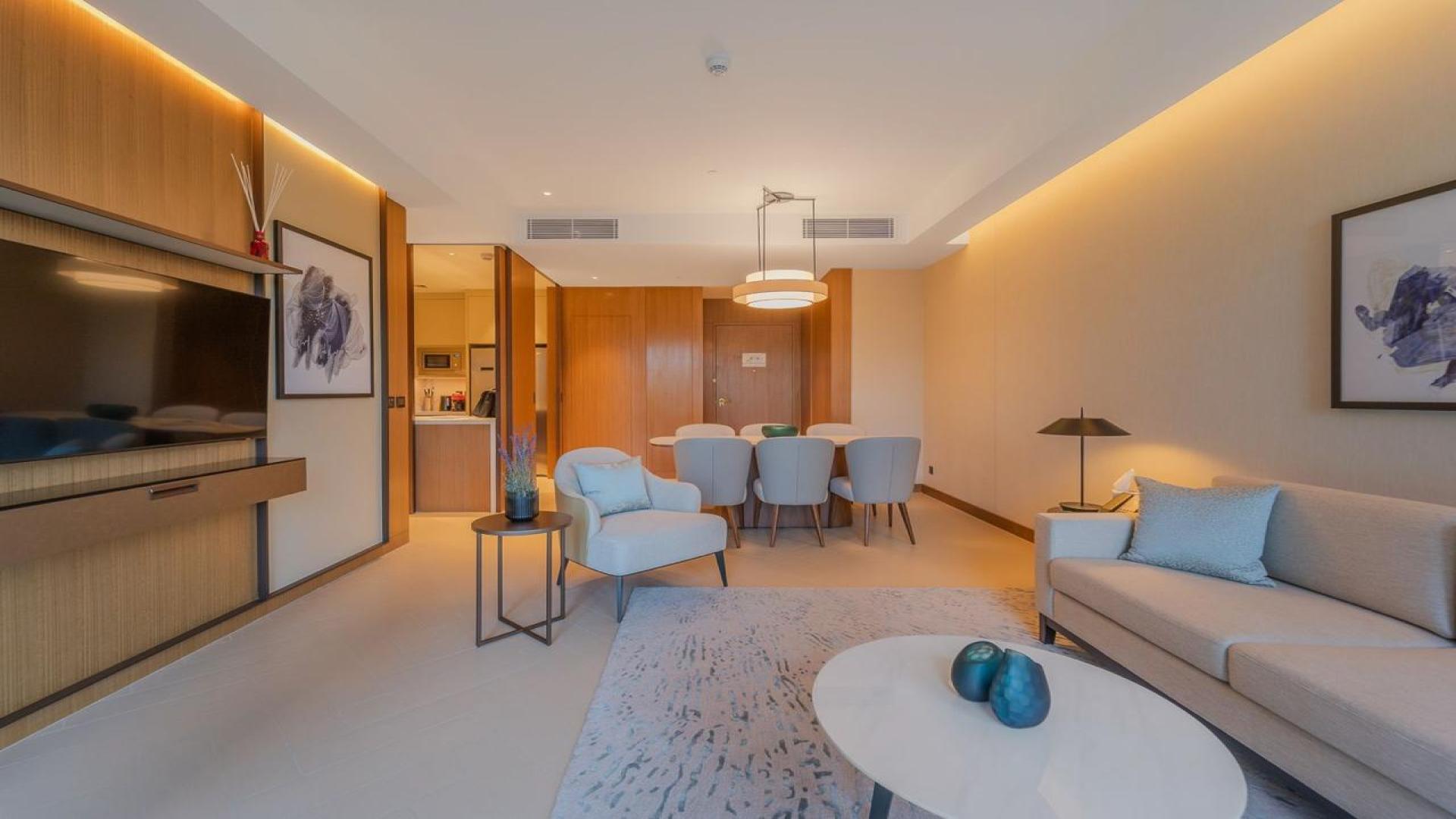 "Stunning view from Address Residences apartment balcony, overlooking Downtown Dubai skyline and greenery.",Furnished living room in Address Residences apartment, Downtown Dubai, with elegant decor and dining area