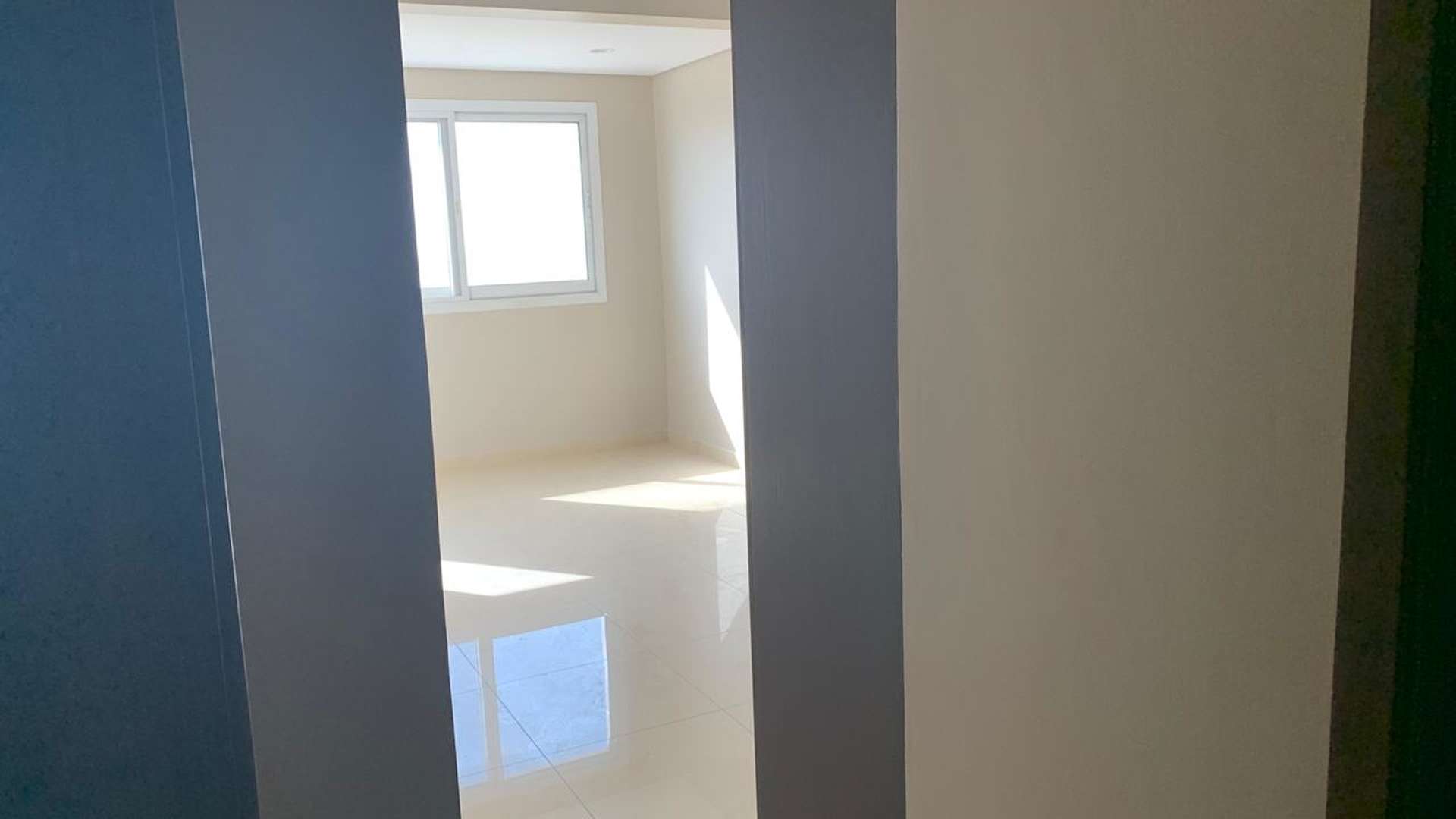 Empty living room with large window in Hercules Tower apartment, Dubailand