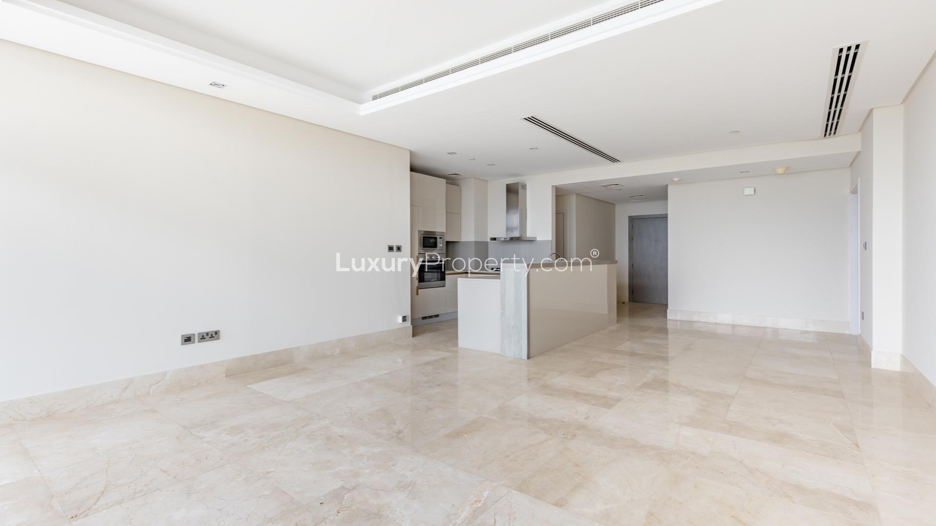 "Bright seafront apartment kitchen with ocean view at 8 on Palm Jumeirah, for sale.",Open-plan kitchen and living area in seafront apartment at 8 on Palm Jumeirah