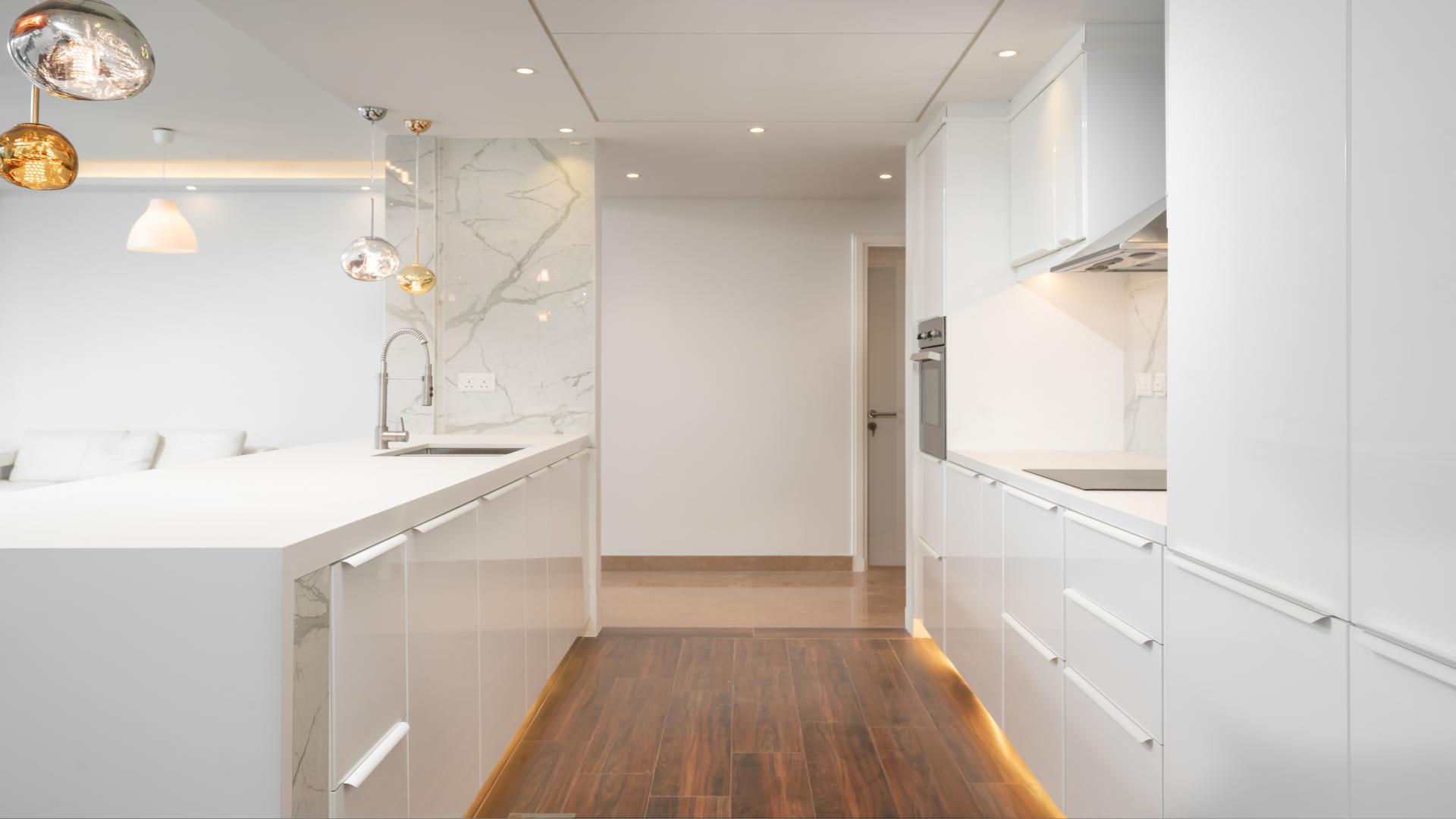 Modern kitchen in fully upgraded 3-bedroom apartment, Dubai Marina, with sleek white cabinetry