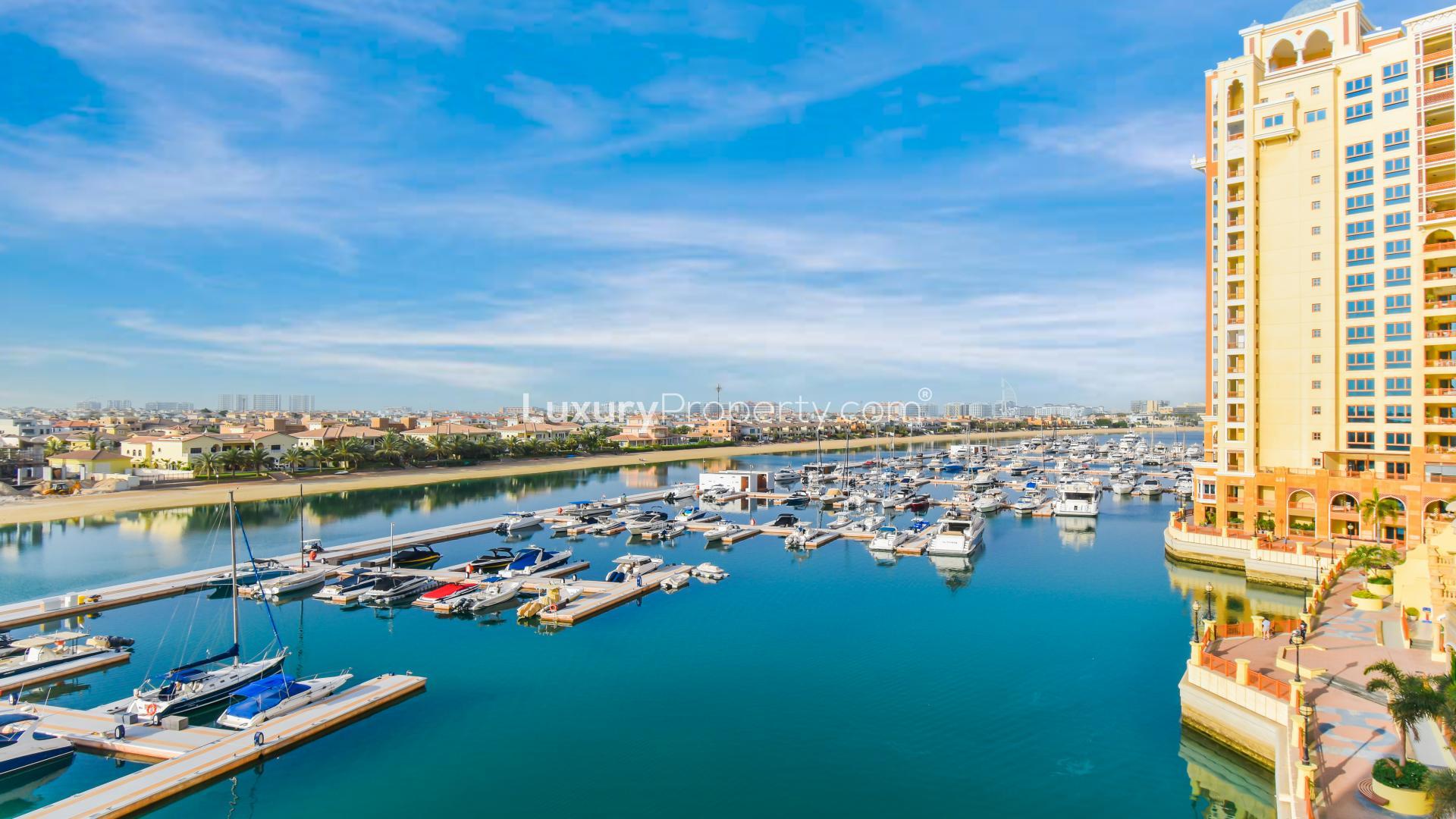 "Spacious balcony with stunning Atlantis views in Marina Residences, Palm Jumeirah apartment.",Modern home office in Palm Jumeirah apartment, featuring bookshelves and a large desk