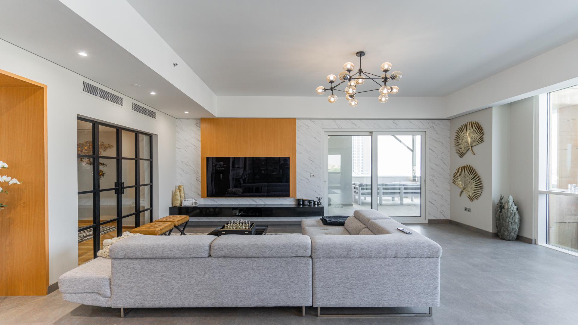 Renovated Palm Jumeirah apartment living room with modern decor, large windows, and elegant lighting