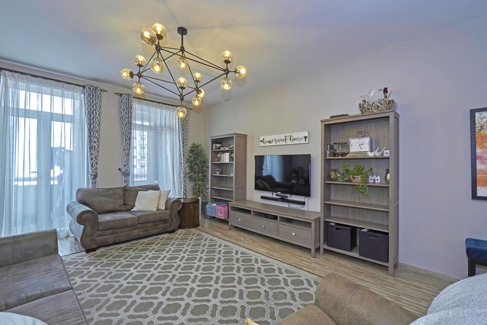 Dining area in 4-bed apartment, Masakin Al Furjan, elegant decor, wooden table, modern lighting
