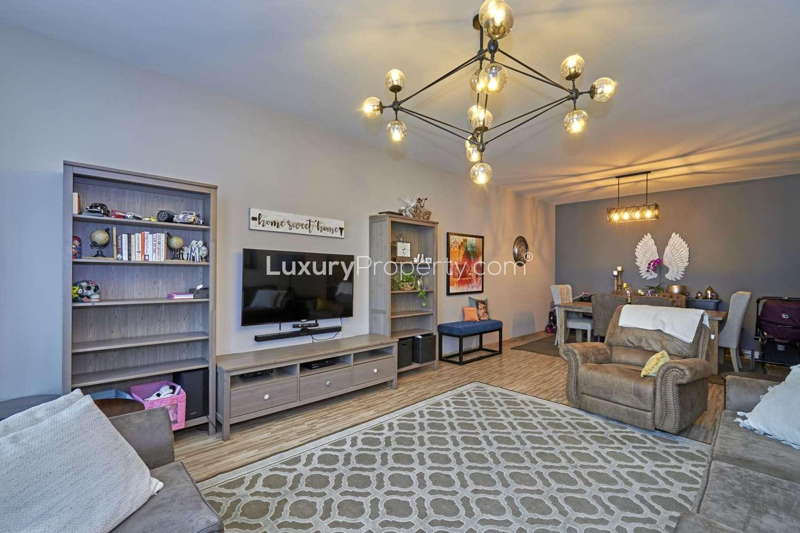 Beautiful pool area at Masakin Al Furjan apartment complex with palm trees and sun loungers