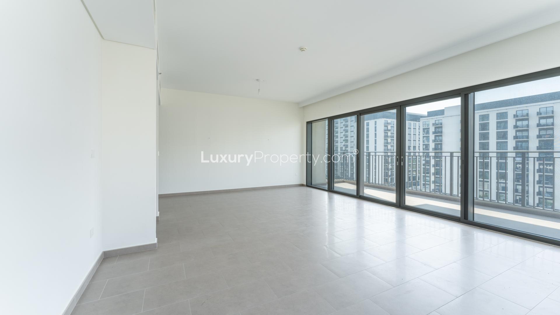 Empty living room with large windows in Dubai Hills 3-bedroom apartment for sale