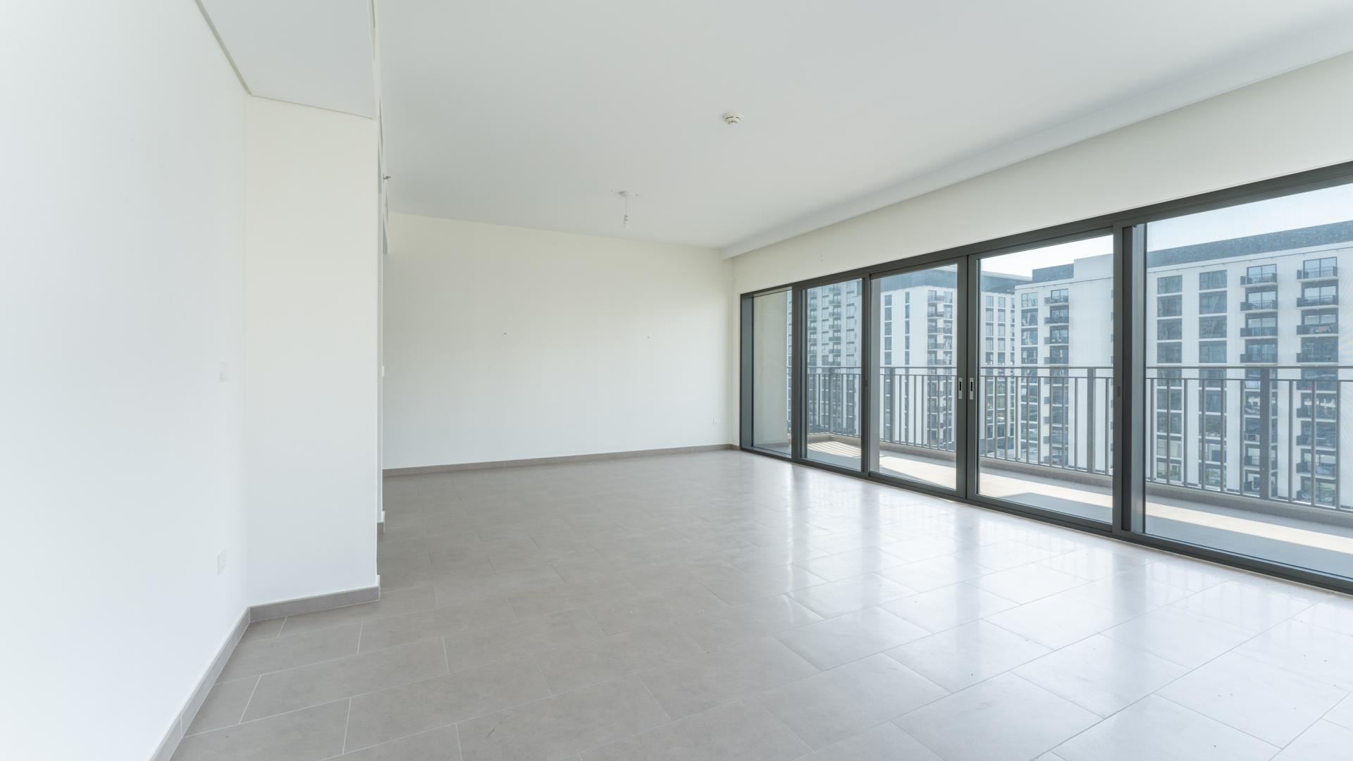 Empty living room with large windows in Dubai Hills 3-bedroom apartment for sale