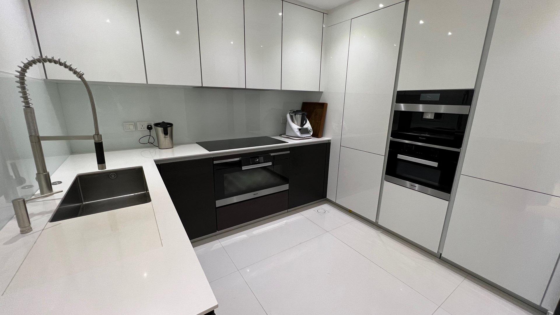 Alt text: "Stunning sea and Marina skyline view from Palm Jumeirah apartment balcony, Oceana community.",Modern kitchen in fully upgraded Palm Jumeirah apartment, sleek cabinetry and high-end appliances