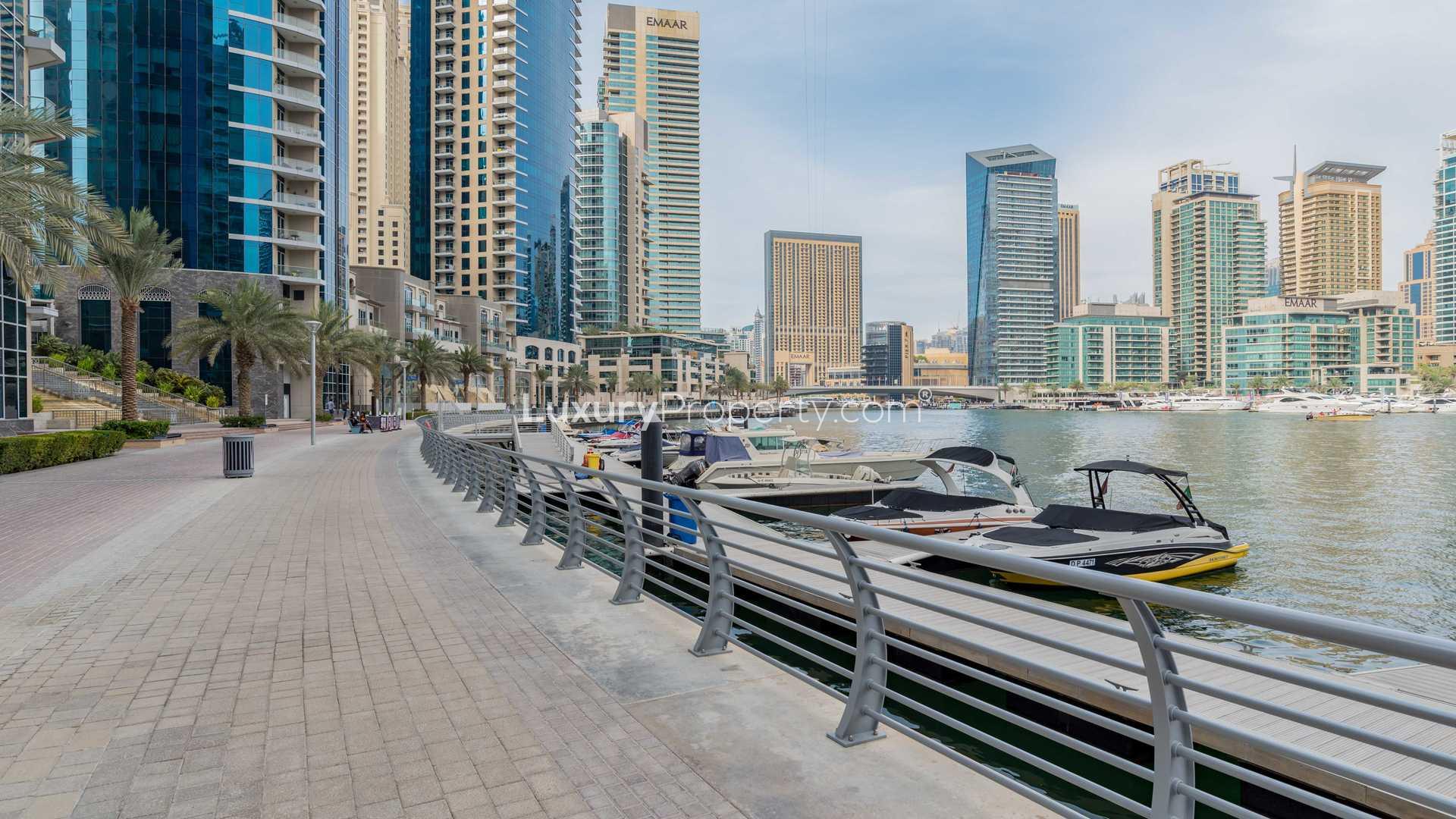 Exterior view of Paloma Tower, Dubai Marina, with marina backdrop and lush greenery