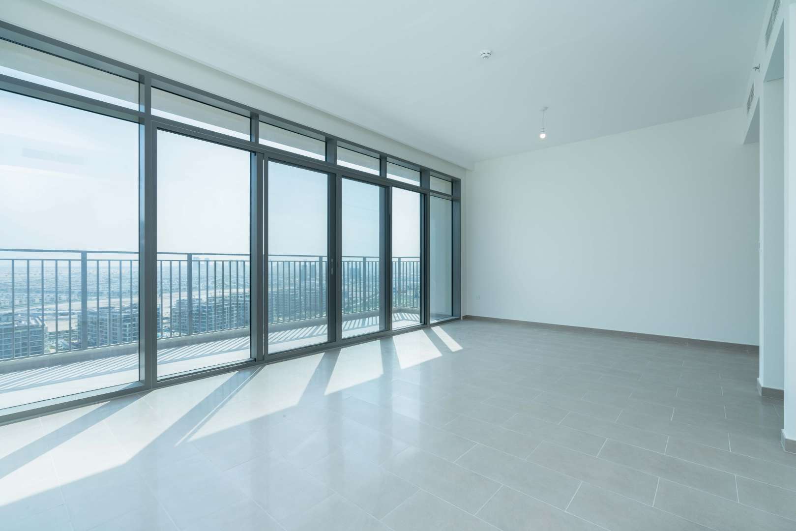 Bright living room with floor-to-ceiling windows in Dubai Hills Estate apartment for sale