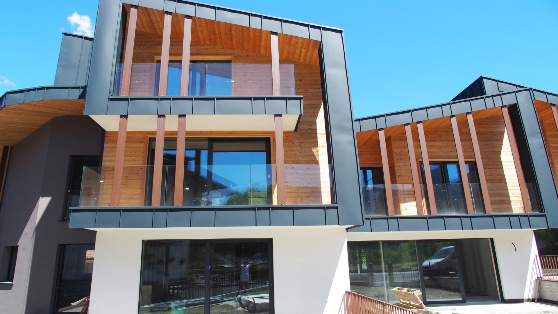 Modern three-bedroom chalet exterior in Pinzolo, Italy, with mountain views. For sale