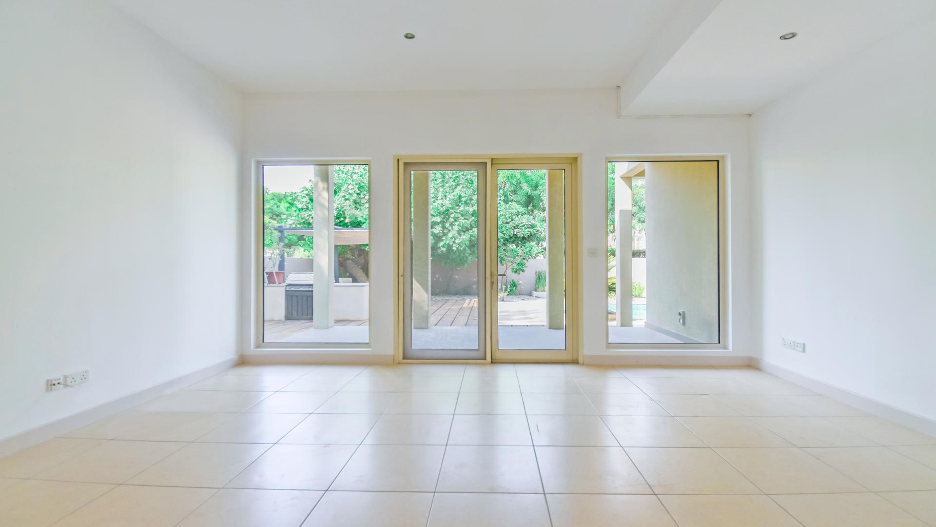 Bright living room with large windows overlooking private pool in Saheel villa, Arabian Ranches