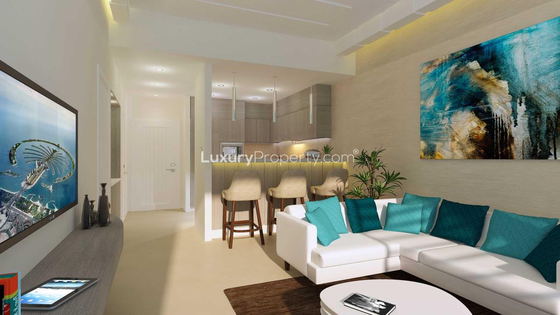 "Modern three-bedroom apartment building in Se7en City JLT, Jumeirah Lake Towers skyline view.",Modern living room in Se7en City JLT apartment, featuring stylish decor and open kitchen