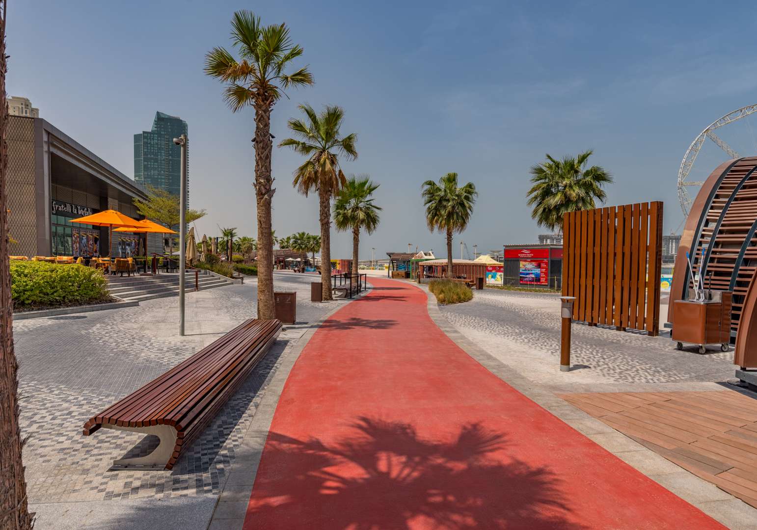 "View from Marvelous Beachfront Apartment balcony in Shams, Jumeirah Beach Residence.",Beachfront promenade near Shams, Jumeirah Beach Residence, showcasing vibrant walkway and palm trees